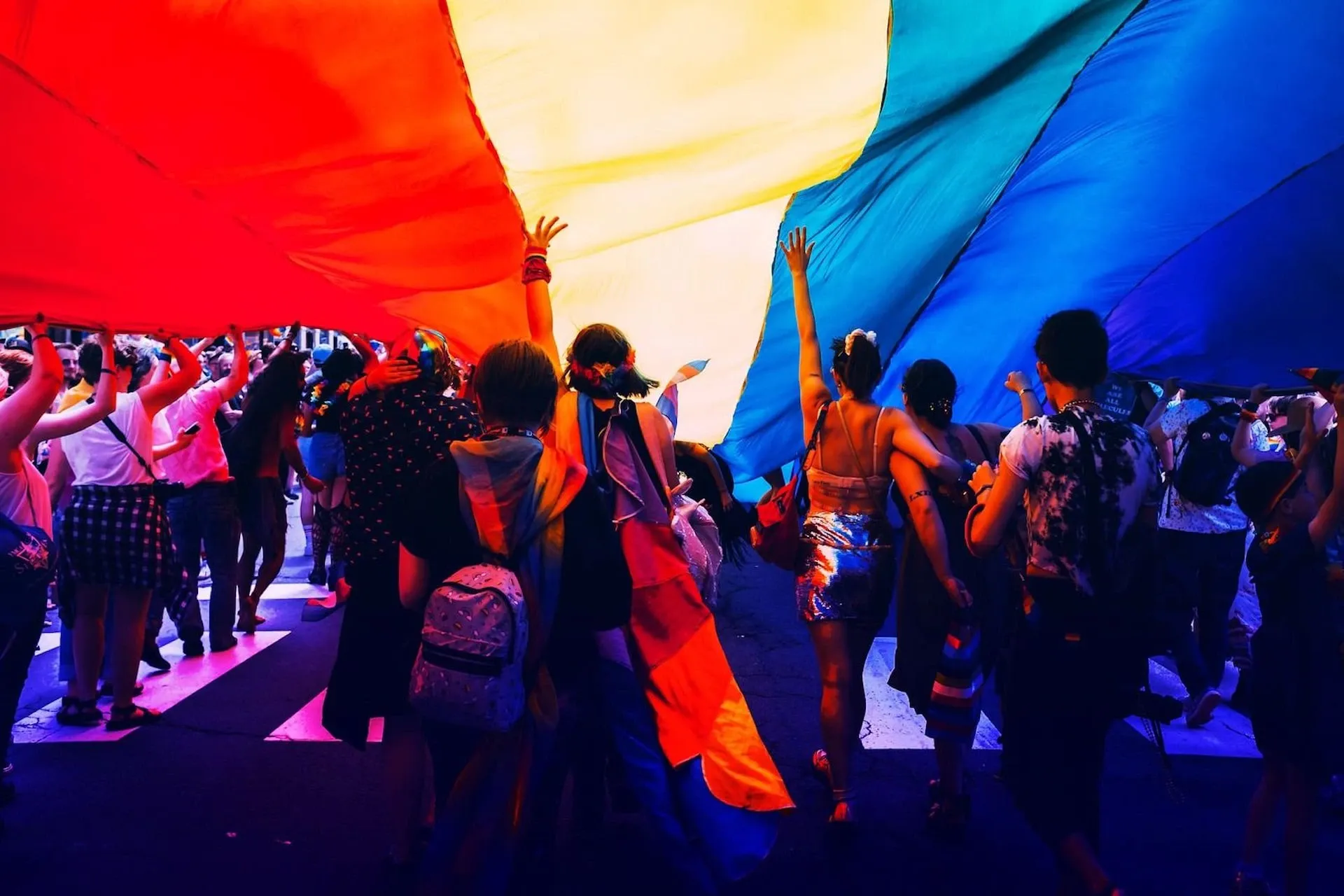 People under a rainbow flag