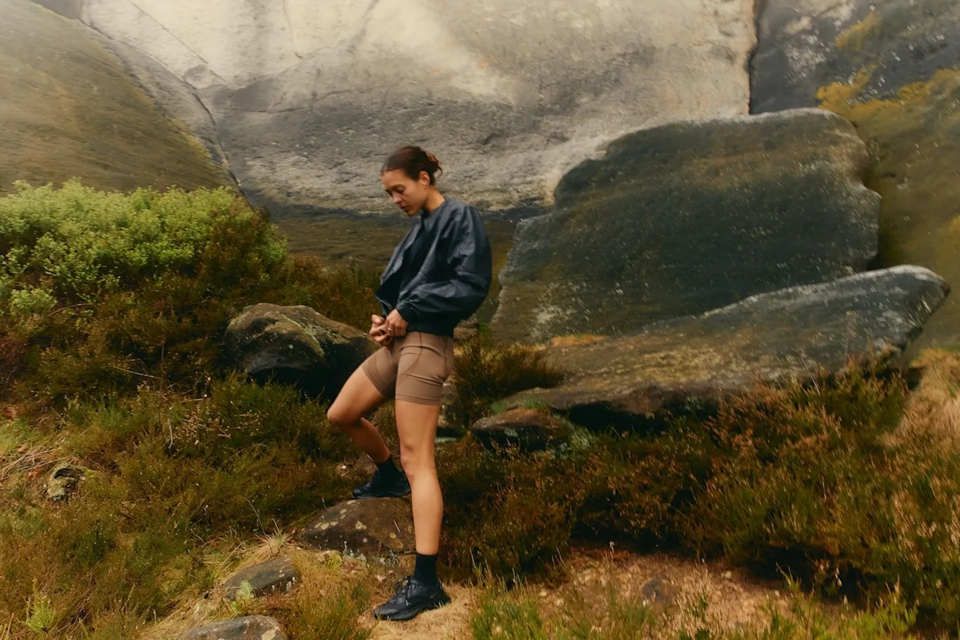 A hiking woman adjusting her raincoat