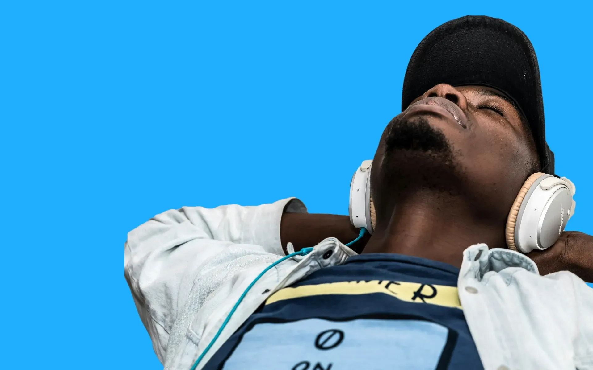 A man sitting back listening to music on headphones