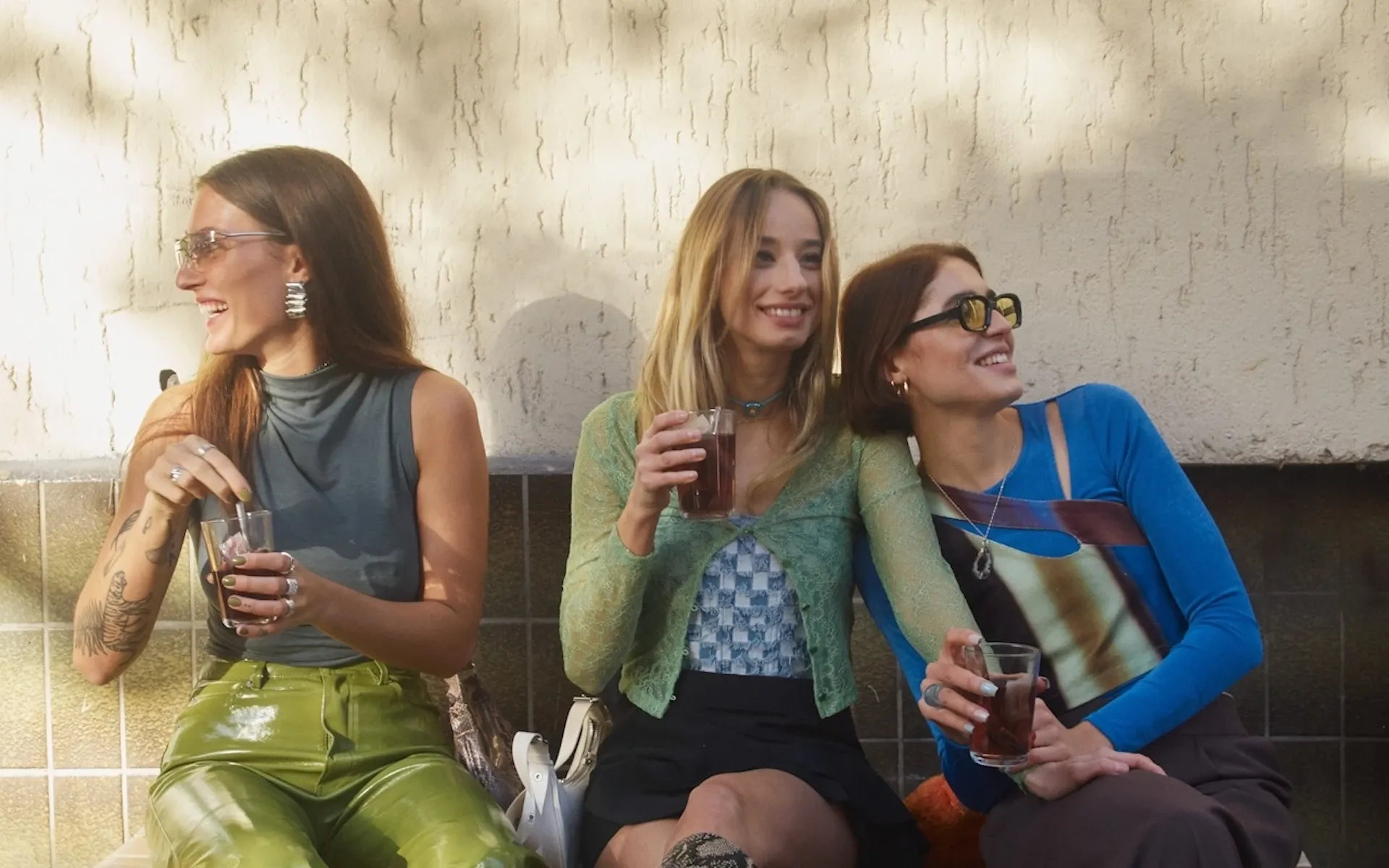A group of friends drinking iced tea on a bench
