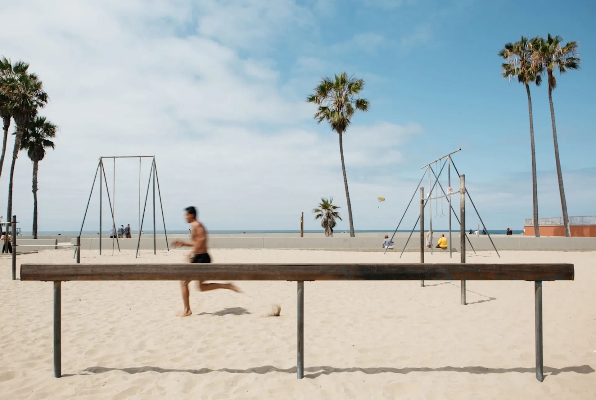 A person running down Venice Beach on a sunny day