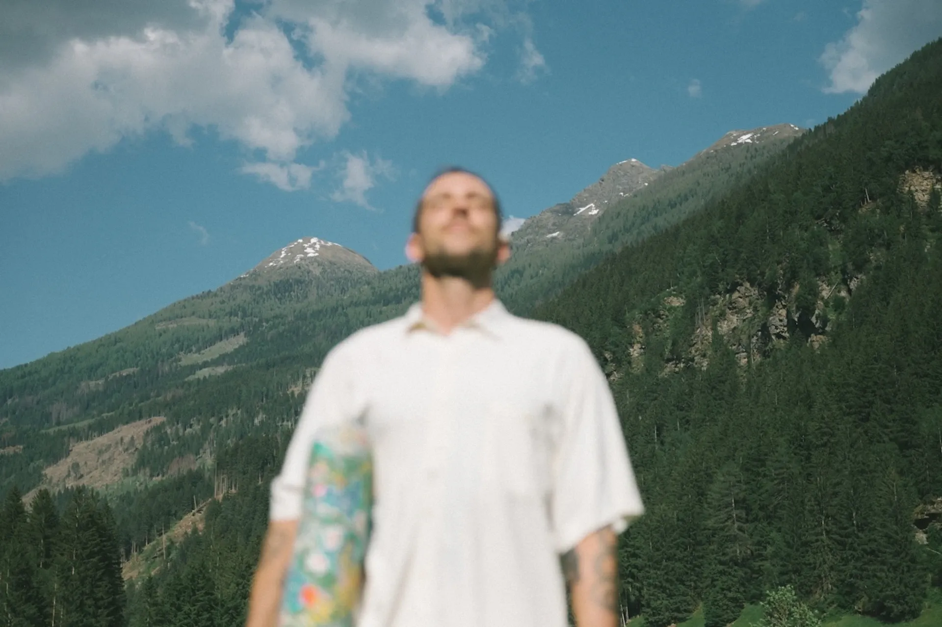 A man standing in front of a mountain range on an overcast day
