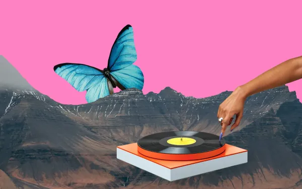 A hand touching a turntable, which is floating in the mountains next to a giant butterfly
